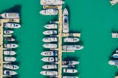 Aerial view of rows of boats docked at a marina in Miami over turquoise water